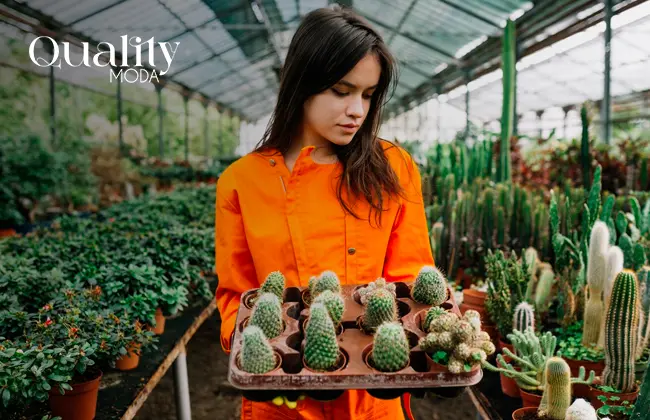 Mujer cargando cactus en un invernadero